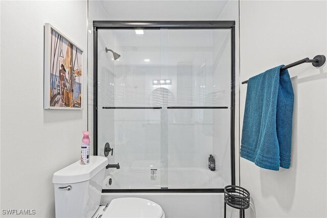 full bathroom with toilet and enclosed tub / shower combo