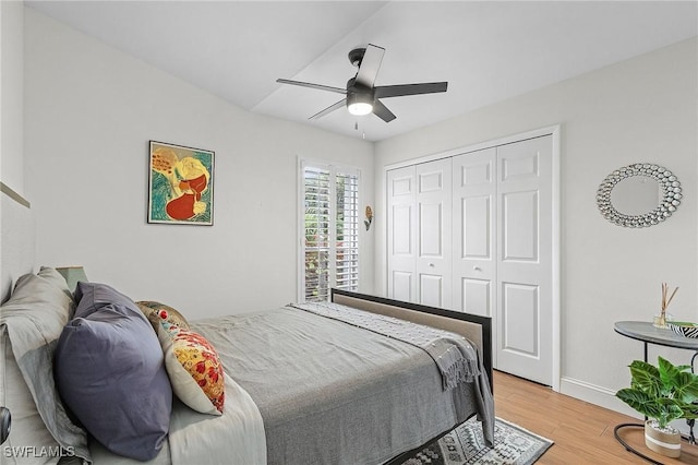 bedroom with light wood-style flooring, a closet, baseboards, and a ceiling fan