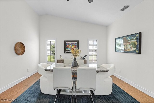 dining space featuring hardwood / wood-style floors, ceiling fan, and lofted ceiling