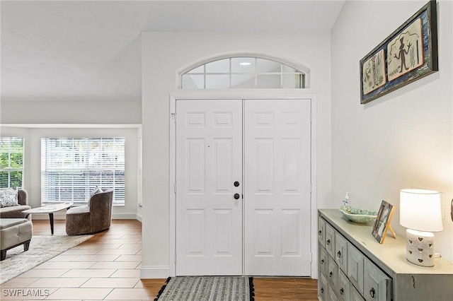 foyer entrance with baseboards and light wood finished floors