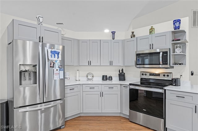 kitchen featuring light wood-type flooring, stainless steel appliances, and gray cabinets