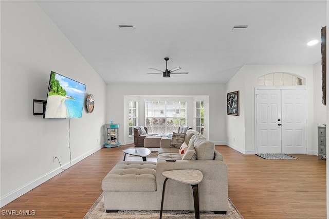 living area with wood finished floors, visible vents, and baseboards