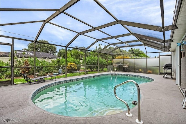 outdoor pool featuring glass enclosure and a patio