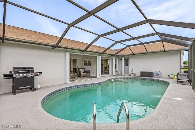 pool featuring a patio area, glass enclosure, and area for grilling