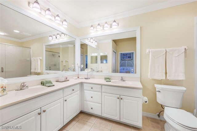 bathroom with tile patterned floors, double vanity, toilet, and ornamental molding