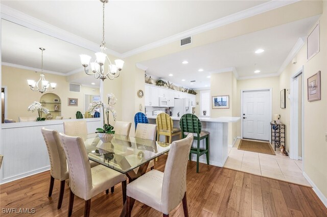 tiled dining room with crown molding and an inviting chandelier