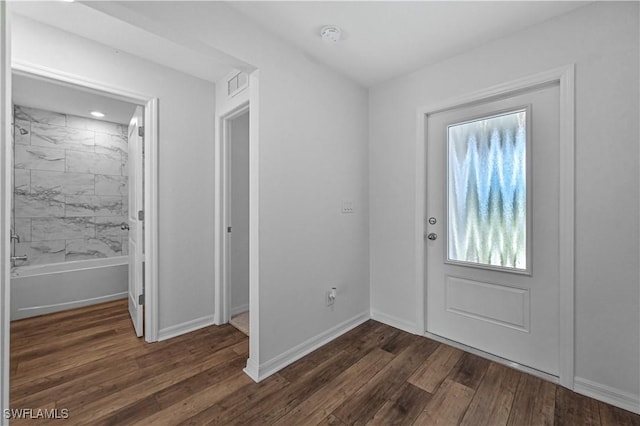 foyer with dark wood-style flooring, visible vents, and baseboards