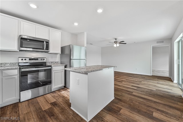 kitchen featuring ceiling fan, appliances with stainless steel finishes, dark hardwood / wood-style flooring, and a center island