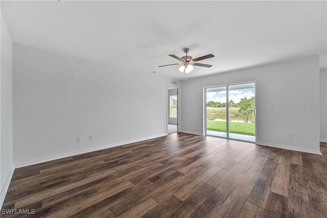 empty room with ceiling fan, visible vents, baseboards, and dark wood-type flooring