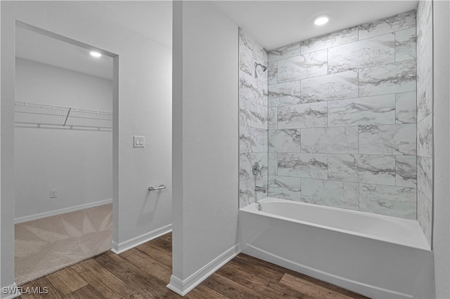 bathroom with hardwood / wood-style flooring and tiled shower / bath combo