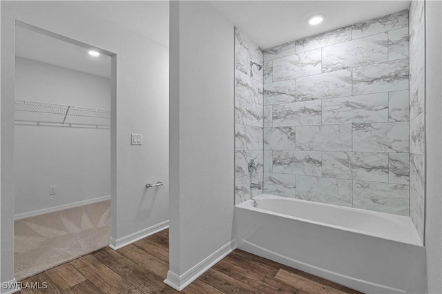 full bath featuring a spacious closet, wood finished floors, shower / tub combination, and baseboards