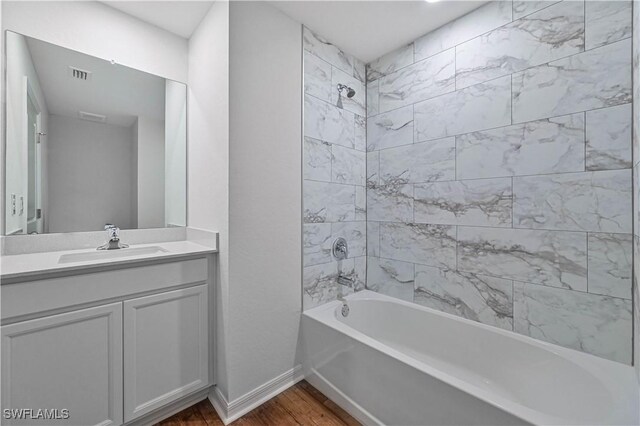 bathroom with vanity, tiled shower / bath, and hardwood / wood-style flooring