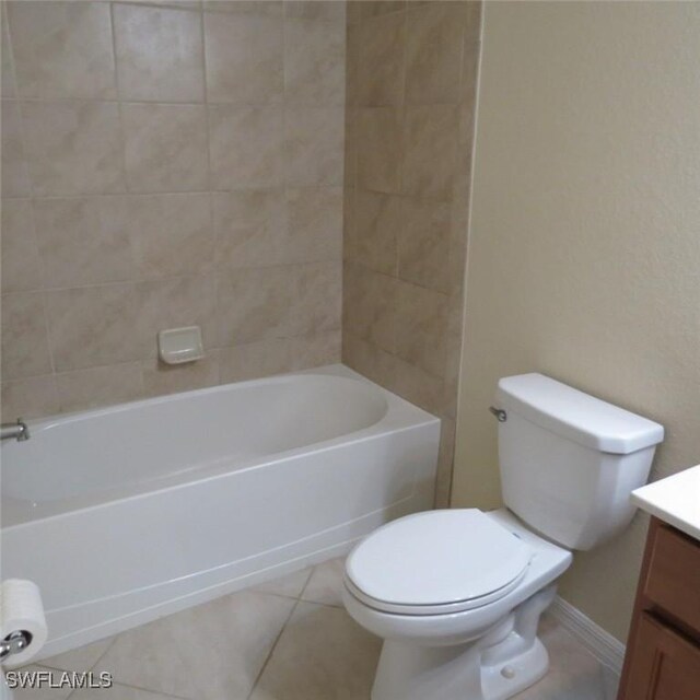 full bathroom featuring vanity, toilet, tiled shower / bath combo, and tile patterned flooring