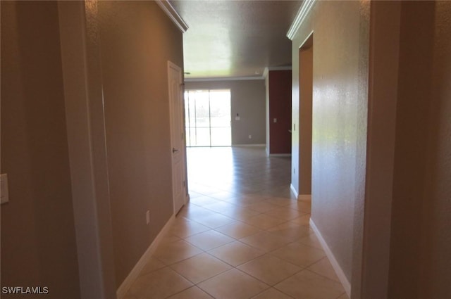 hall featuring ornamental molding and light tile patterned floors