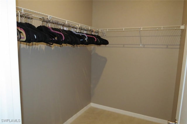 spacious closet with tile patterned floors