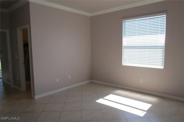 spare room with crown molding and light tile patterned floors