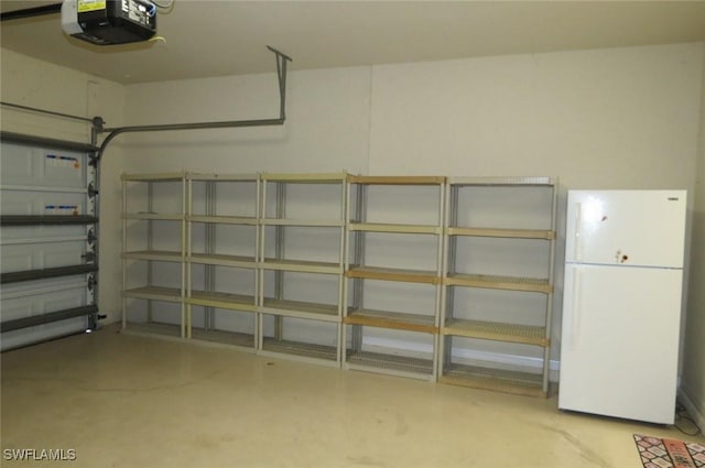 garage with a garage door opener and white fridge