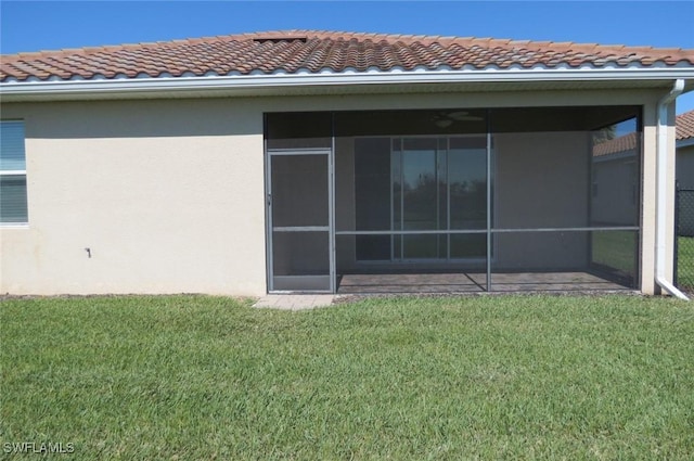 back of property with a sunroom and a yard