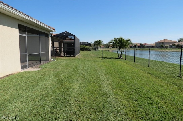 view of yard with a water view and a lanai