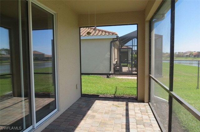 unfurnished sunroom with a water view