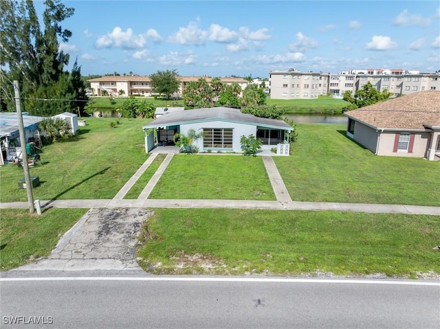 3107 Easy St, Port Charlotte, FL 33952 - view of front facade featuring driveway, a front lawn, and a water view