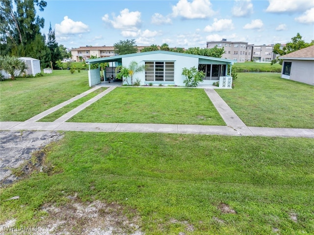 view of front of house with a carport and a front yard