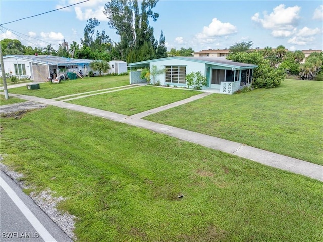 3107 Easy St, Port Charlotte, FL 33952 - view of front of property featuring a sunroom, a front yard, an attached carport, and driveway