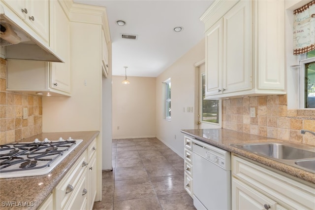 kitchen with light tile patterned floors, backsplash, white appliances, and light stone countertops