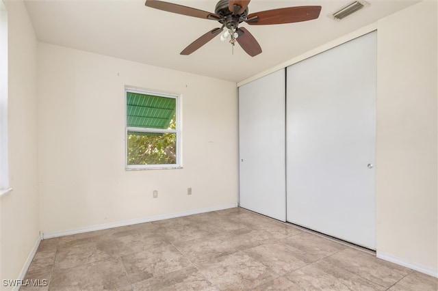 unfurnished bedroom with ceiling fan, light tile patterned floors, and a closet