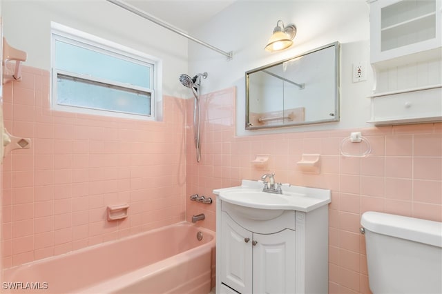 full bathroom with toilet, tiled shower / bath, tile walls, vanity, and decorative backsplash