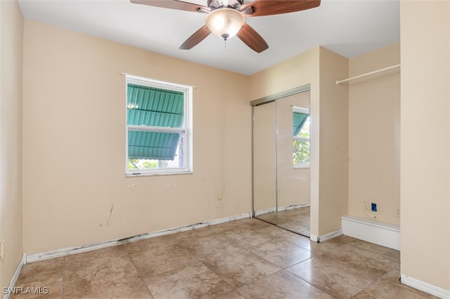 unfurnished bedroom with ceiling fan, multiple windows, a closet, and light tile patterned floors