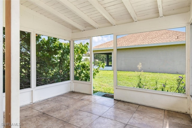 unfurnished sunroom with vaulted ceiling with beams