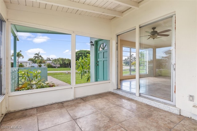 unfurnished sunroom with vaulted ceiling with beams and ceiling fan