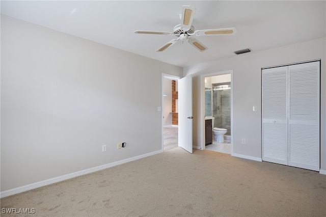 unfurnished bedroom with connected bathroom, ceiling fan, a closet, and light colored carpet