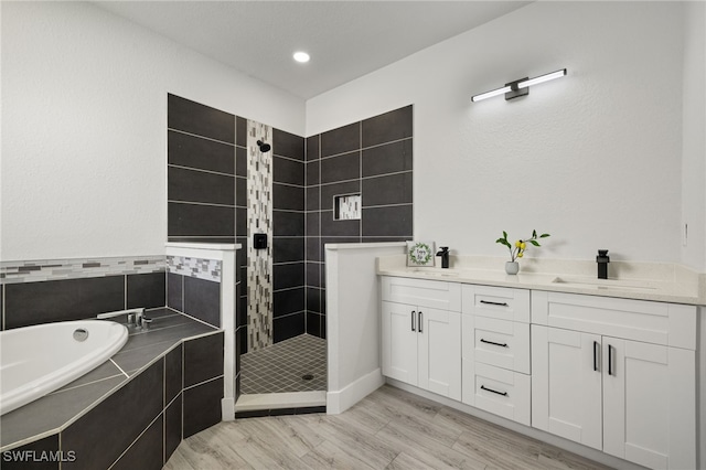 bathroom with vanity, hardwood / wood-style floors, and independent shower and bath