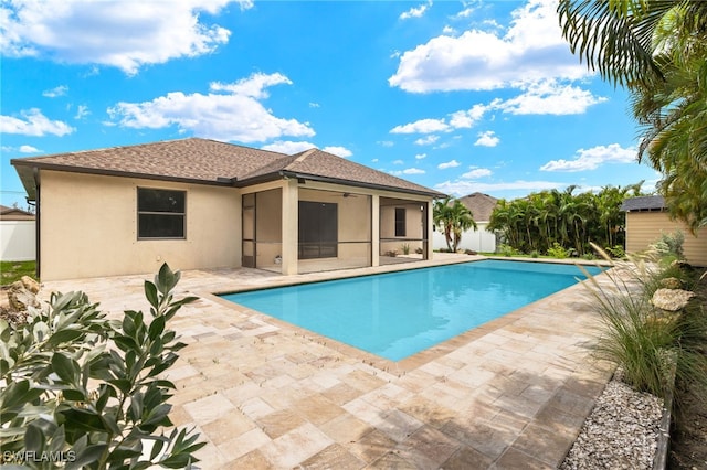 view of pool with a patio, a sunroom, and ceiling fan