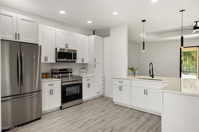 kitchen featuring sink, decorative light fixtures, white cabinets, and appliances with stainless steel finishes