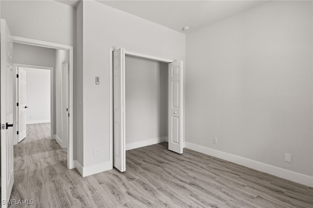 unfurnished bedroom with a closet and light hardwood / wood-style flooring