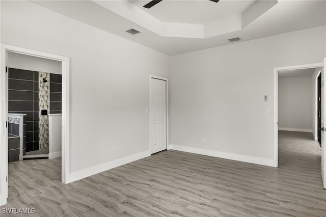 spare room with hardwood / wood-style floors, a raised ceiling, and ceiling fan