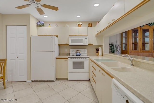 kitchen featuring white appliances, white cabinets, ceiling fan, light tile patterned flooring, and sink