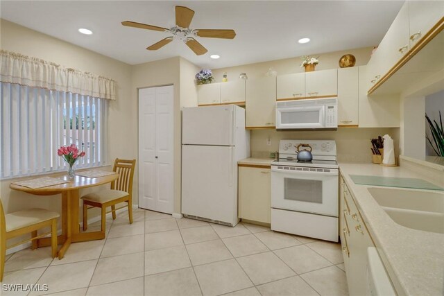 kitchen with ceiling fan, sink, white appliances, and light tile patterned floors