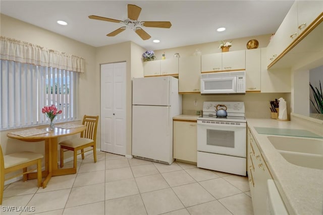 kitchen featuring light tile patterned flooring, sink, white appliances, and ceiling fan