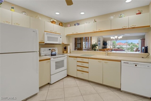 kitchen with sink, ceiling fan with notable chandelier, white appliances, and light tile patterned floors