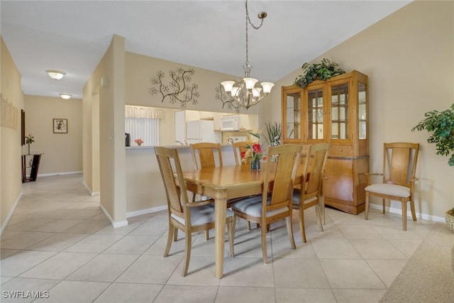 dining area featuring light tile patterned flooring and a chandelier