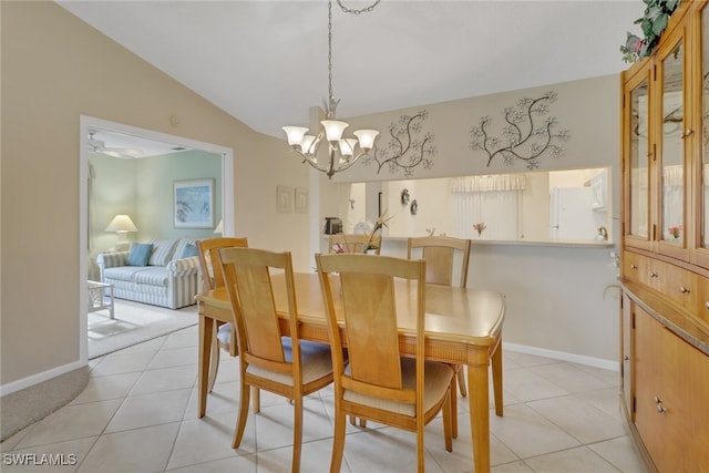 tiled dining room featuring ceiling fan with notable chandelier and vaulted ceiling