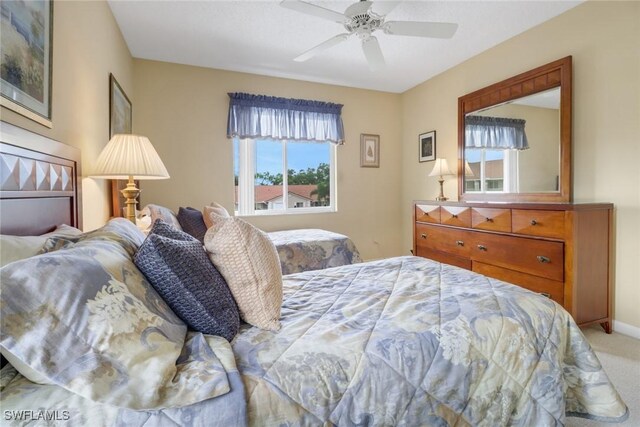 bedroom with ceiling fan, multiple windows, and light colored carpet