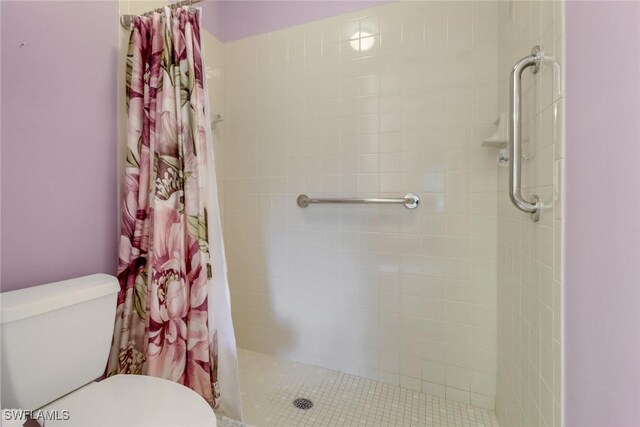 bathroom featuring a shower with shower curtain and toilet