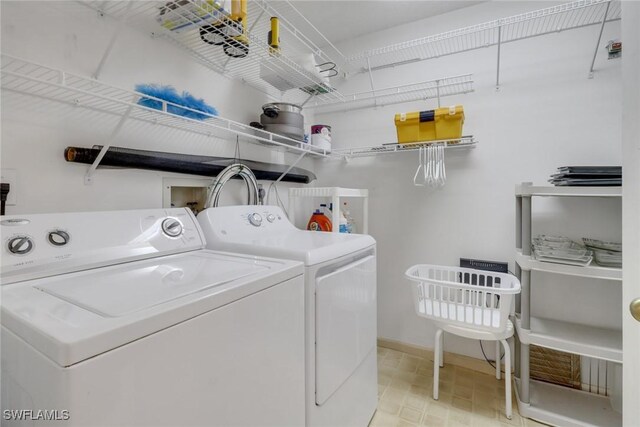 laundry room with light tile patterned flooring and washing machine and dryer