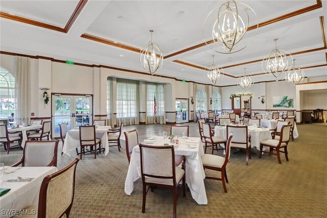 carpeted dining space featuring a raised ceiling, french doors, and an inviting chandelier