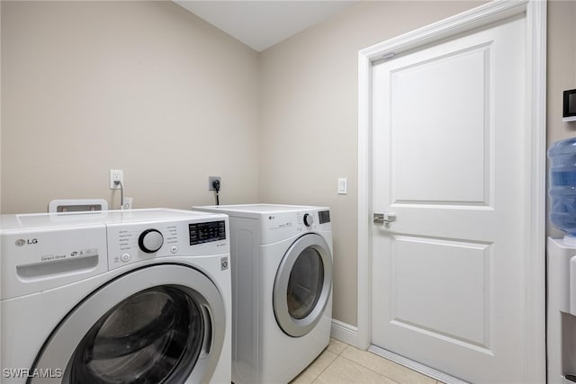 washroom with separate washer and dryer and light tile patterned flooring